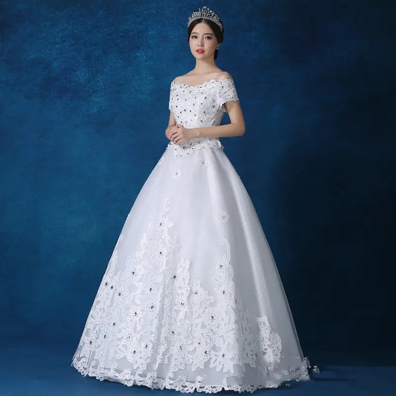 A white off-the-shoulder wedding gown featuring intricate lace detailing and beaded embellishments made from main fabric by qidi studio wholesale.