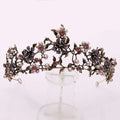 An ornate floral black diamond pearl baroque bridal crown with white pearls and purple pink gemstone floral design