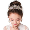 A delicate gold-toned princess crown tiara with an intricate floral design and sparkling clear and pink crystals