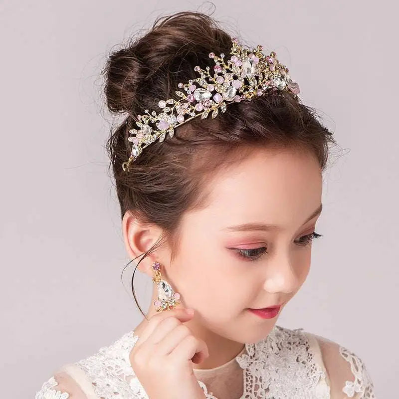 Delicate gold-toned princess crown tiara with intricate floral design featuring clear and soft pink crystals