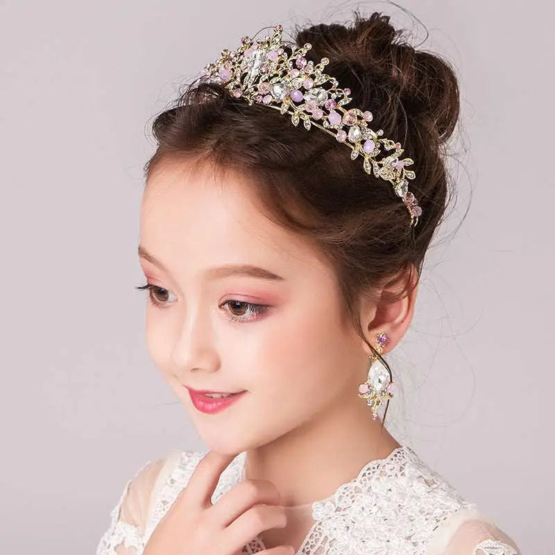 A delicate gold-toned princess crown tiara with sparkling pink and clear crystals and an intricate floral design