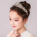 A delicate gold-toned princess crown tiara with sparkling pink and clear crystals and an intricate floral design