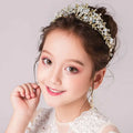 Delicate gold-toned princess crown tiara with an intricate floral design featuring clear and light blue crystals