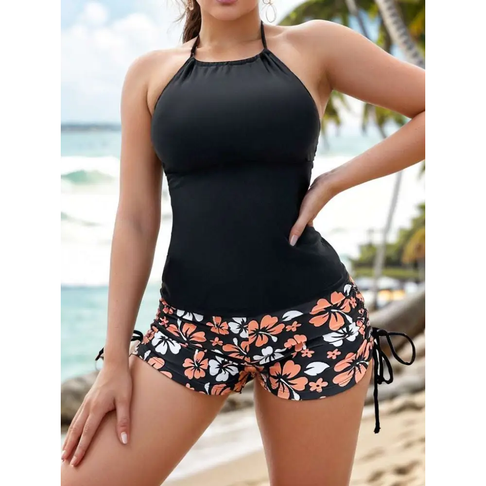 Black halter top paired with orange and white floral shorts in a floral halterneck printed halter split swimsuit design
