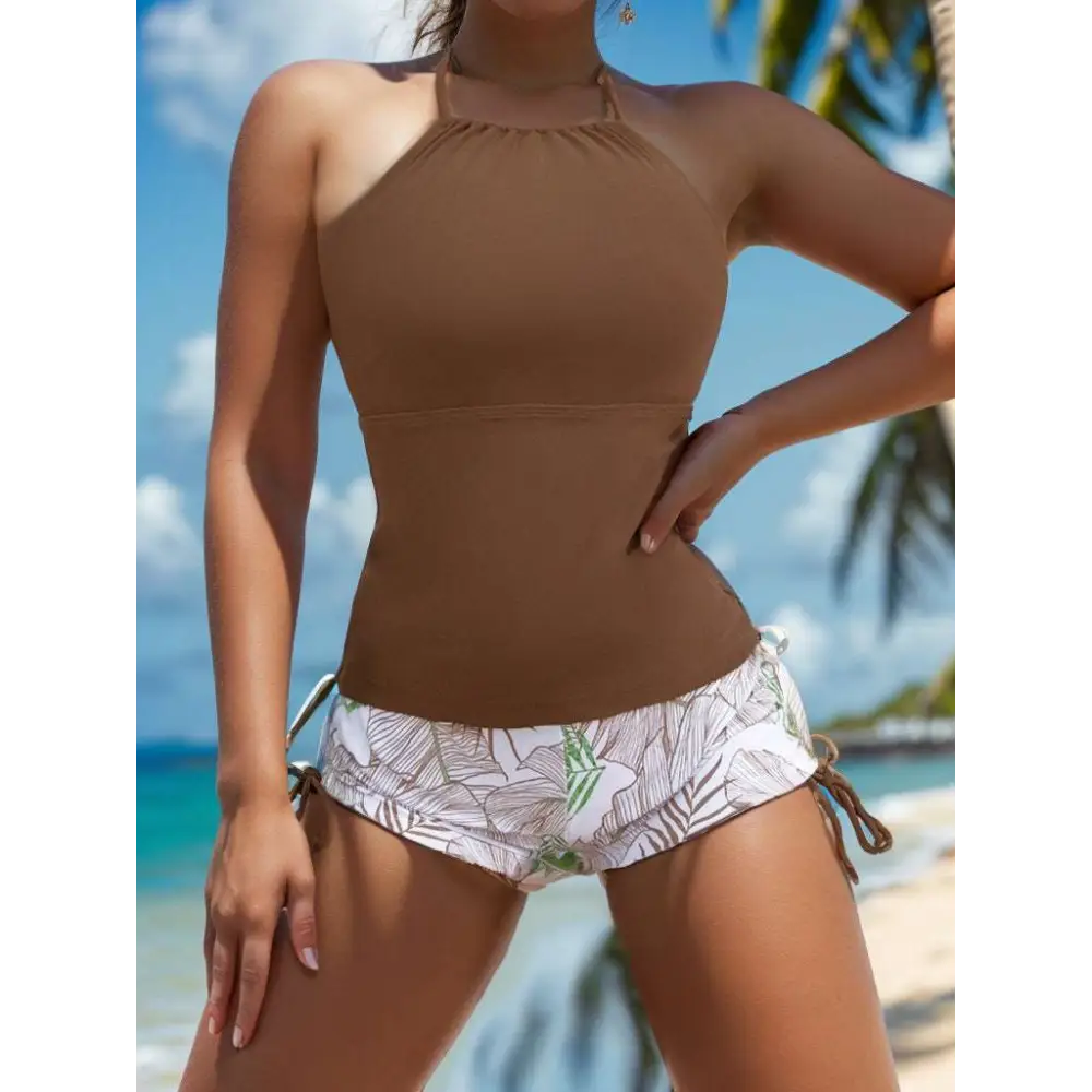 Brown floral halterneck printed halter bikini with white tropical leaf shorts featuring side ties in halter split swimsuit style