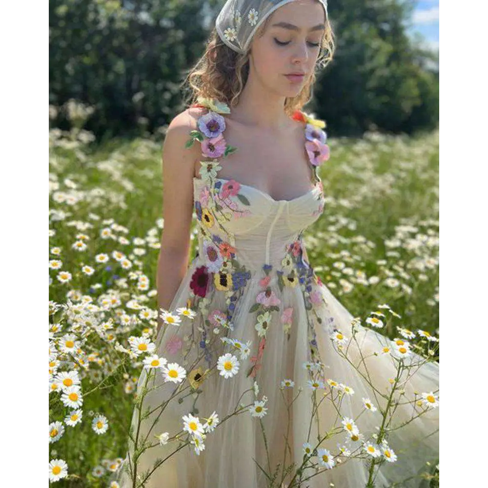 A delicate off-white champagne tulle prom dress with vibrant floral appliqués in pink purple yellow and blue
