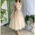 Delicate off-white champagne tulle prom dress with intricate multi-hued floral appliqués on bodice and skirt