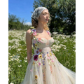 Delicate off-white champagne tulle prom dress with vibrant three-dimensional floral appliqués in pink yellow purple and orange
