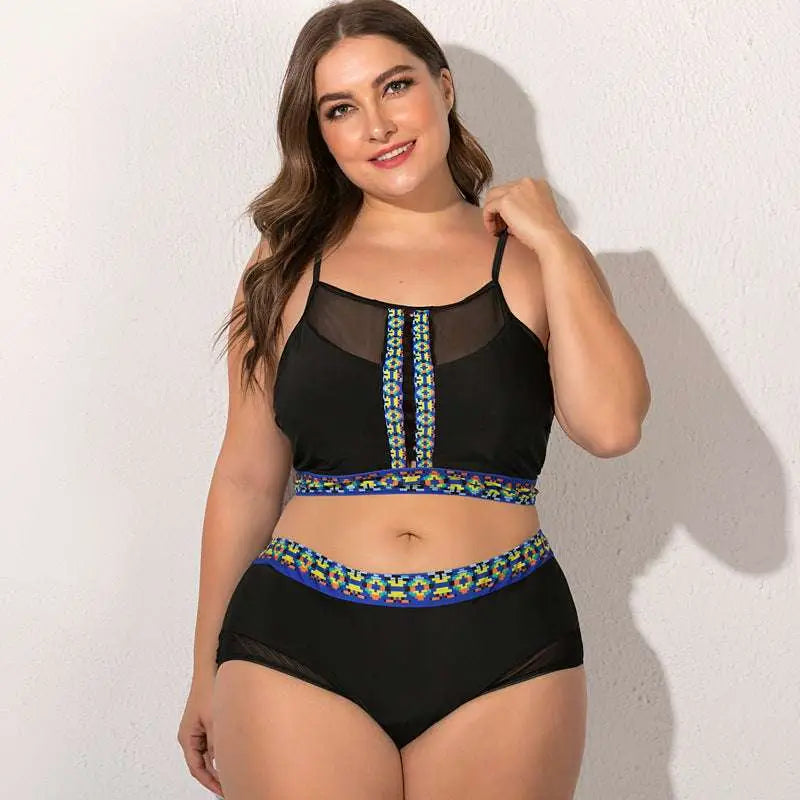 Black plus-size two-piece female swimsuit with floral mesh sheer mesh panels and vibrant geometric trim along front zipper