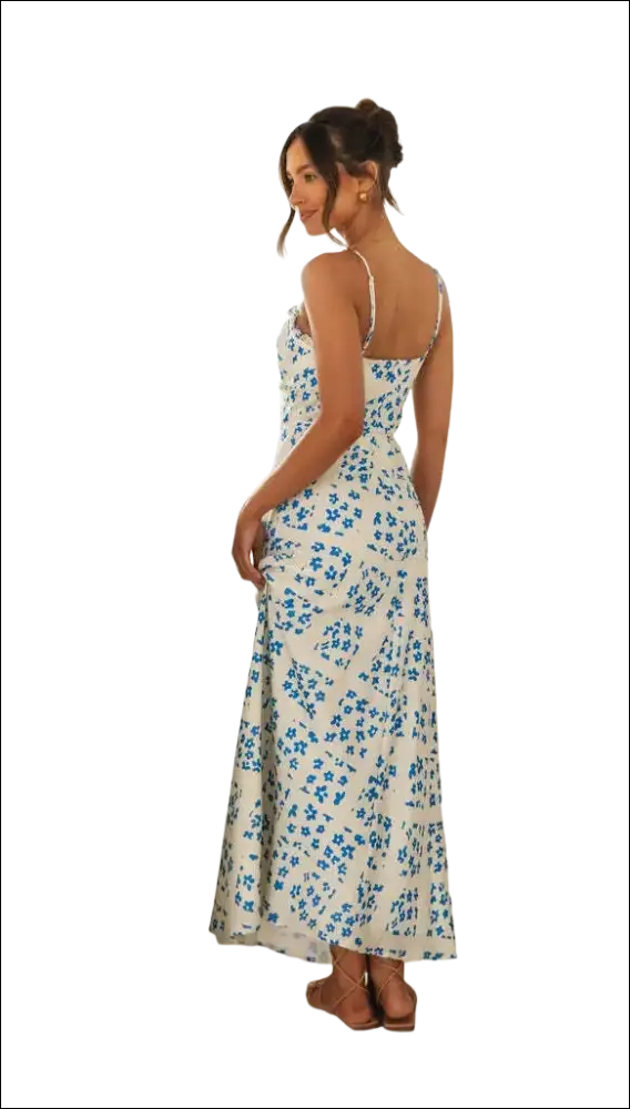 A white floral print maxi dress with delicate blue patterns, thin spaghetti straps, and a flattering swing skirt fit