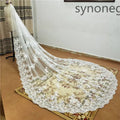 A delicate white cathedral length bridal lace veil with intricate floral embroidery and scalloped edge displayed on a mannequin