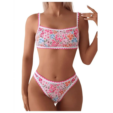 A floral scalloped women two piece bathing suit featuring vibrant pink blue and orange blossoms on white fabric