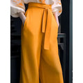 Vibrant mustard-yellow high-waisted trousers with self-tie belt paired with floral silk slimming flab hiding shirt set