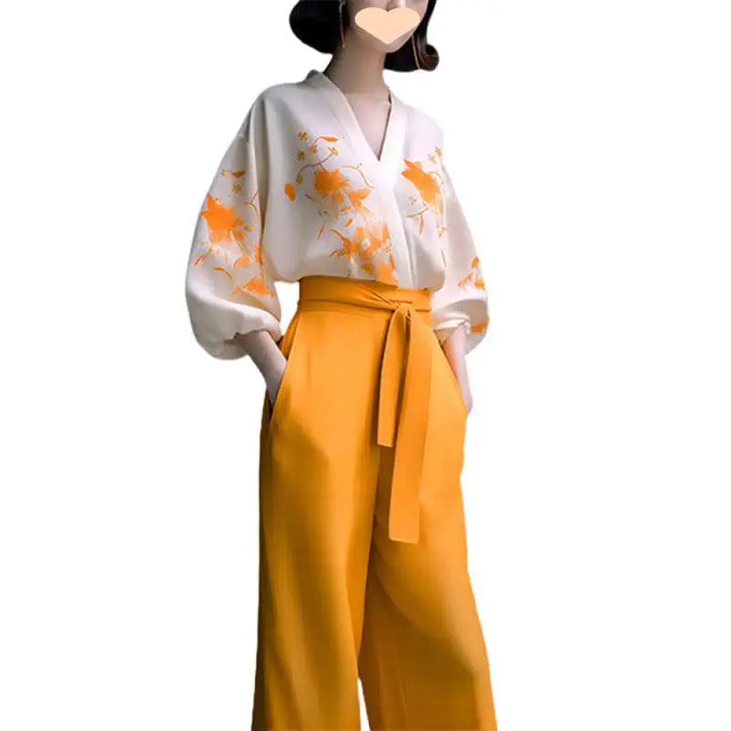 A woman wears a floral silk slimming white blouse with orange embroidery and a flab hiding shirt set in mustard yellow
