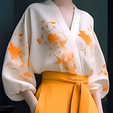 A flowing white floral silk slimming blouse with vibrant orange embroidery made from lightweight fabric hiding flab