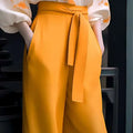Vibrant mustard-yellow high-waisted trousers with self-tie belt paired with floral silk slimming flab hiding shirt set