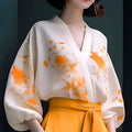 A flowing off-white floral silk slimming blouse with delicate orange embroidery and wide puffy sleeves hiding shirt set