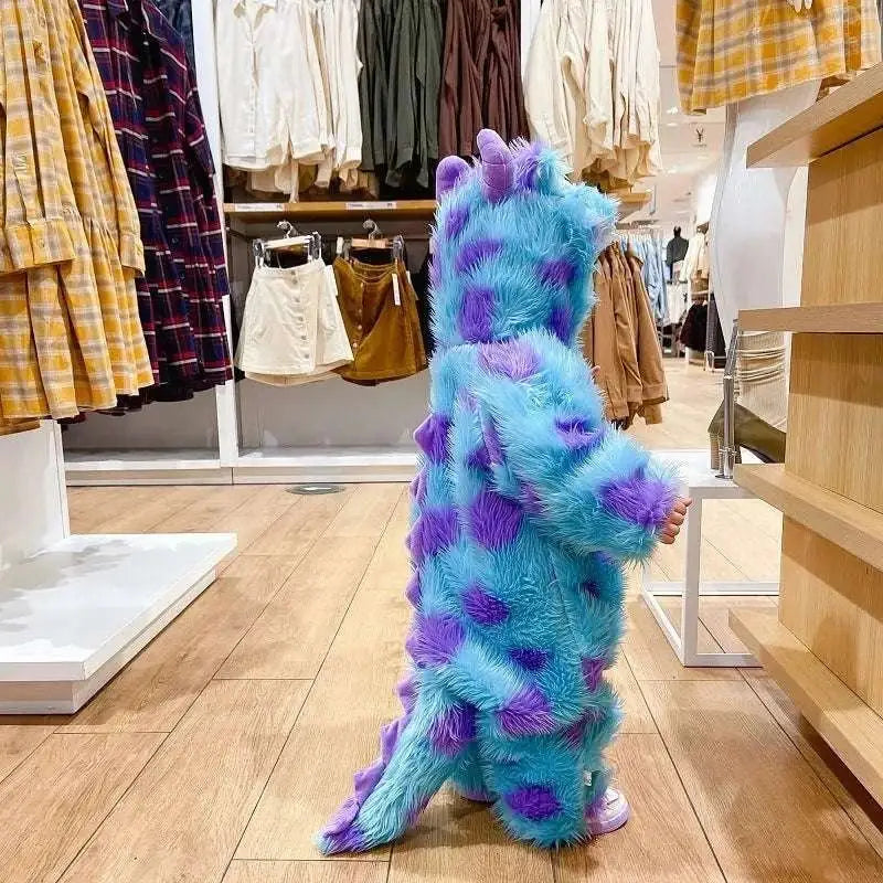 A child wearing a fluffy monster cute blue and purple spotted animal baby jumpsuit resembling sulley from Monsters Inc