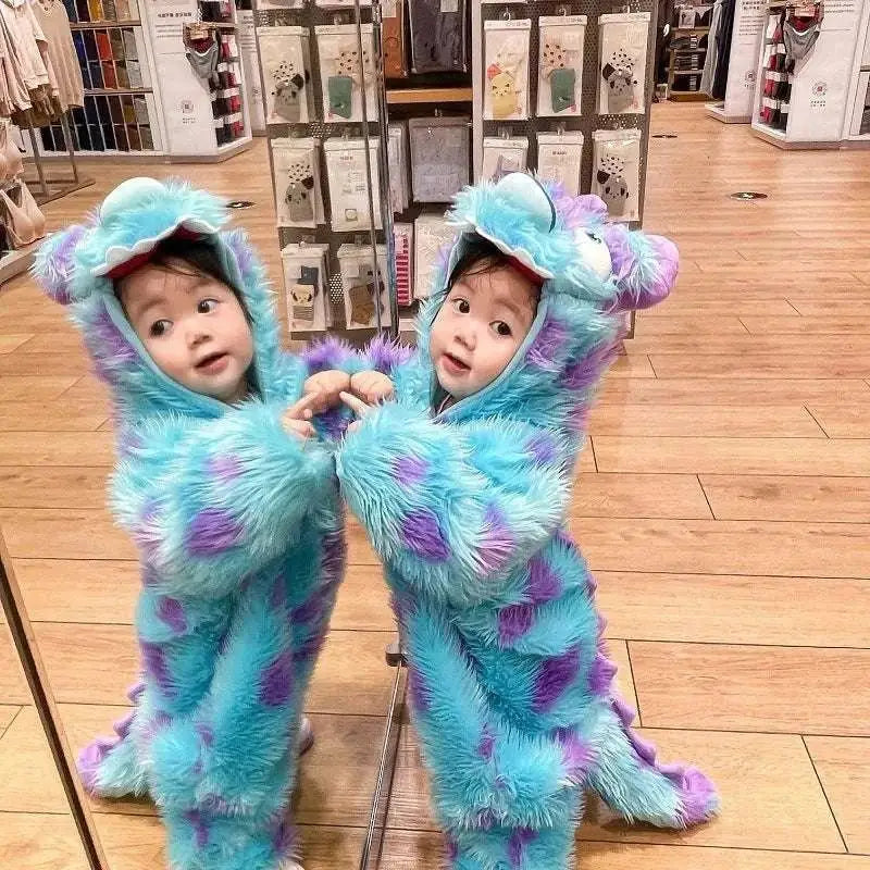 Two toddlers in matching fluffy blue and purple monster cute animal baby jumpsuits with large ears and tails