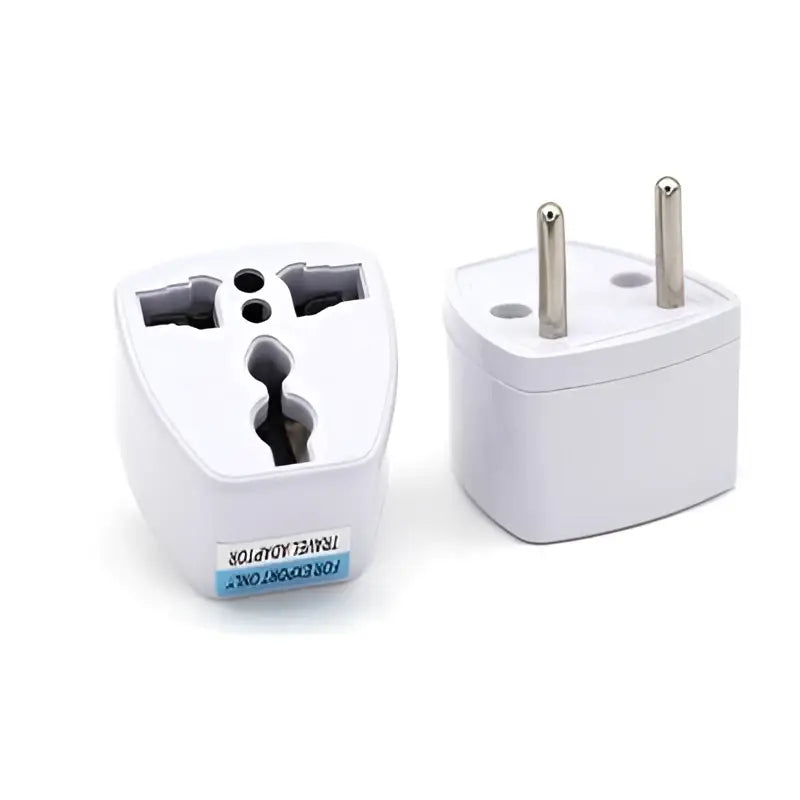 White plastic travel adapter with multiple metallic pins designed for small quick dryer with circular control panel and gray fabric