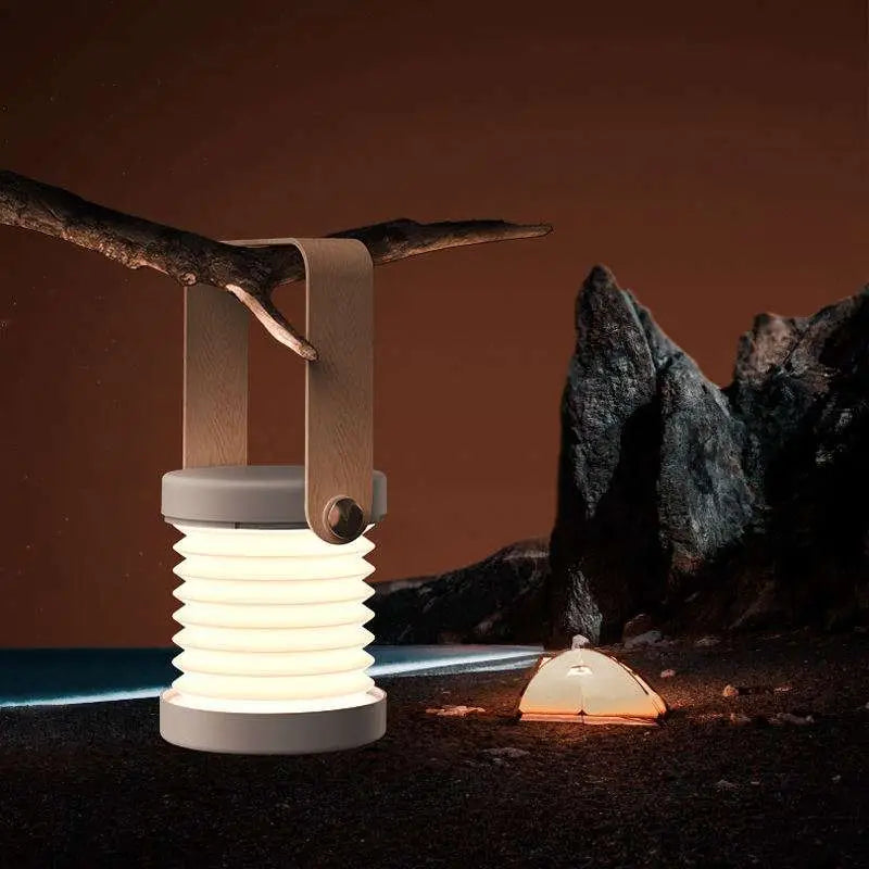 A sleek white foldable touch dimmable portable lantern with a minimalist wooden handle and soft ambient glow
