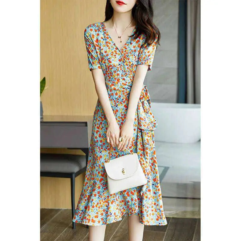 A woman wearing a french floral slim polka dot wrap dress with short sleeves and a v-neckline carrying a white handbag
