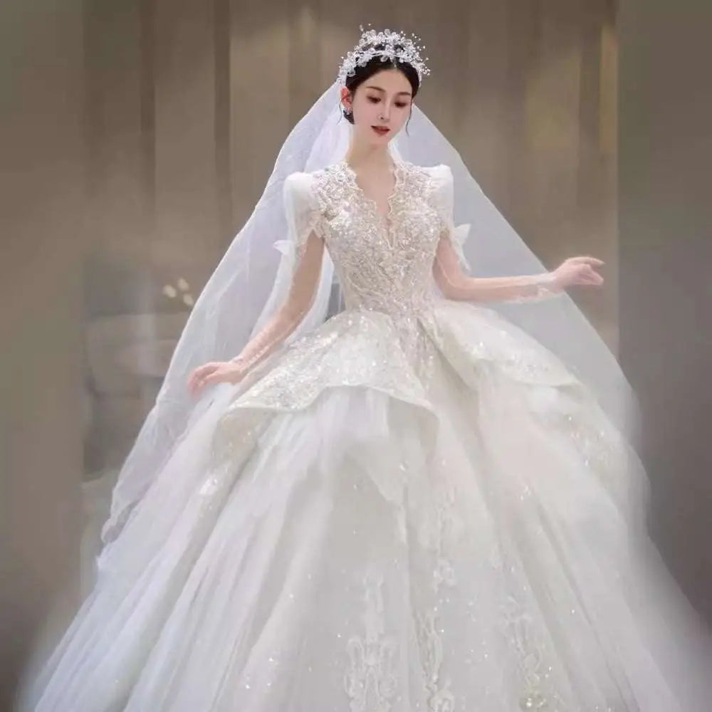 A sparkling white wedding gown with intricate beading and yarn long sleeve detailing in french retro bride style