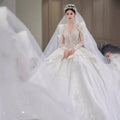 A bride wears a white french retro bride yarn long sleeve wedding gown with intricate lace beading and floral headpiece