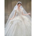 A sparkling white french retro bride wedding gown with yarn long sleeves, intricate beading, lace, and a voluminous skirt