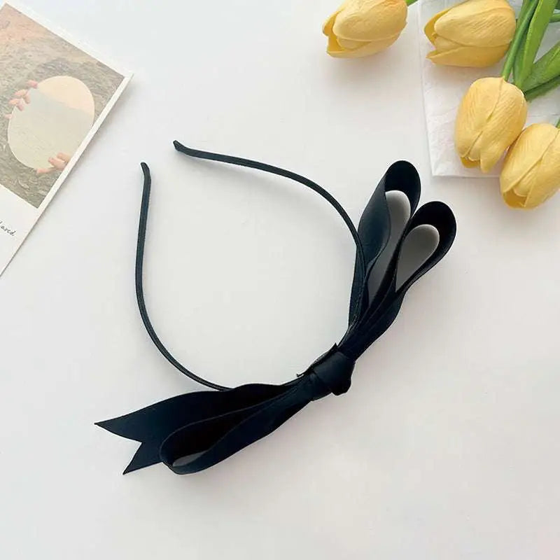 A collection of french satin bow headbands in pastel and deep burgundy hues featuring large satin bows
