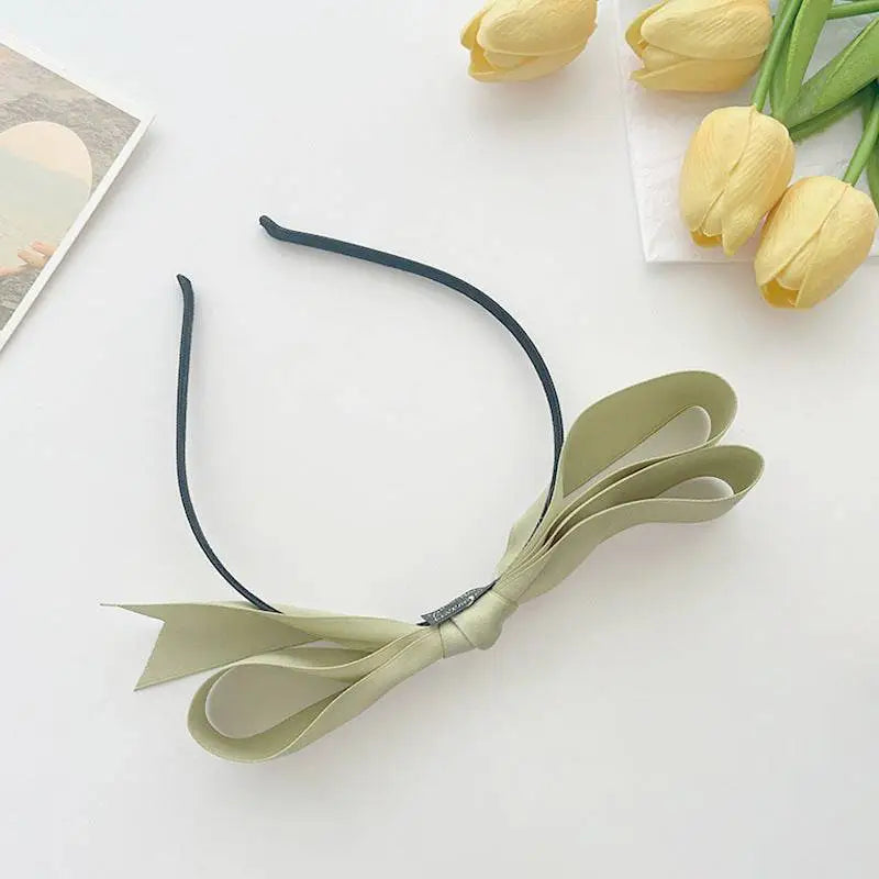 Delicate sage green french satin bow headband with a sleek black satin bow headband elastic band for women