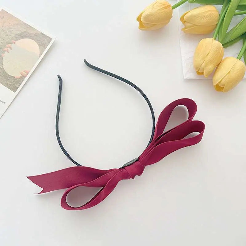 A sleek black bow headband featuring a plush deep burgundy french satin bow for women