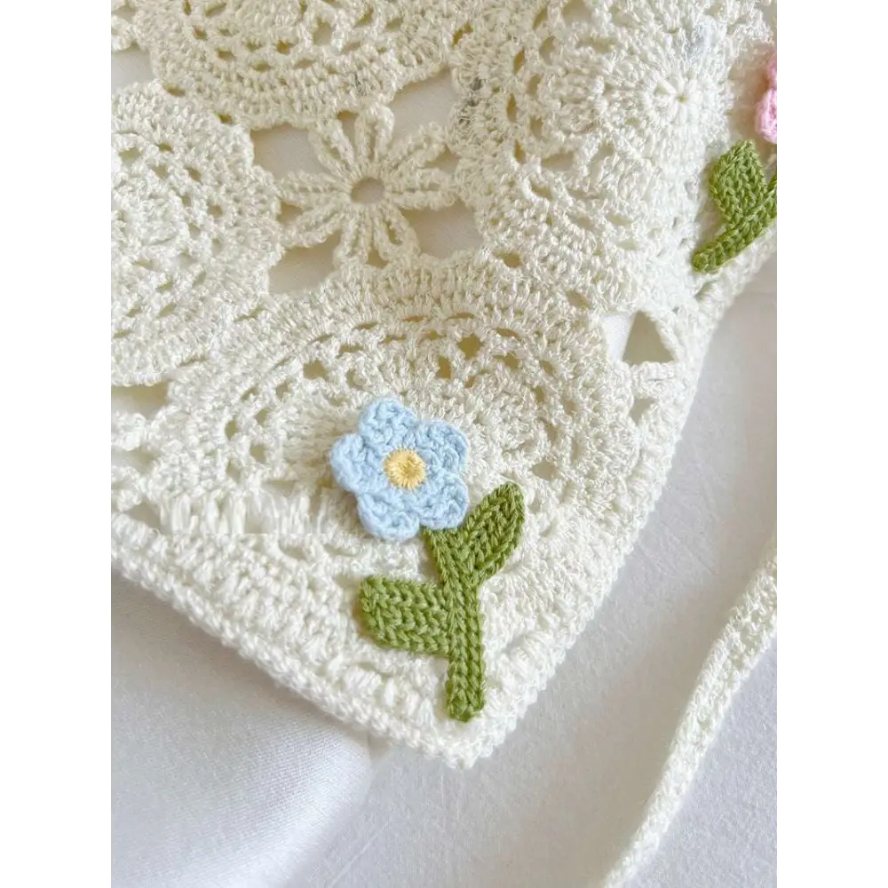 Delicate off-white crocheted french style triangular binder knitted headband with light blue flower and yellow center