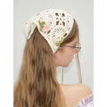 Delicate off-white crocheted French style triangular binder knitted headband with embroidered flowers and green leaves