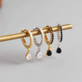 A set of french style wind silver hoop earrings with black zirconia, gold, silver, and black finishes with crystal teardrop charms