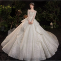 A sparkling white wedding evening gown from the temperament dream collection with long sheer sleeves and tulle skirt