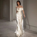 A french white off-shoulder satin wedding dress in soft ivory with elegant draping and a sleek silhouette