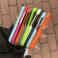 A hand holds colorful silicone frosted finish half-pack graphite cases designed for heat dissipation and protection