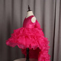 A vibrant fuchsia layered ruffled flower girl tuxedo dress with lace bodice and trailing skirt for special occasions
