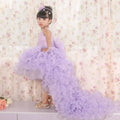 A young girl wears a fuchsia layered ruffled flower girl tuxedo dress with sheer overlay and matching headband