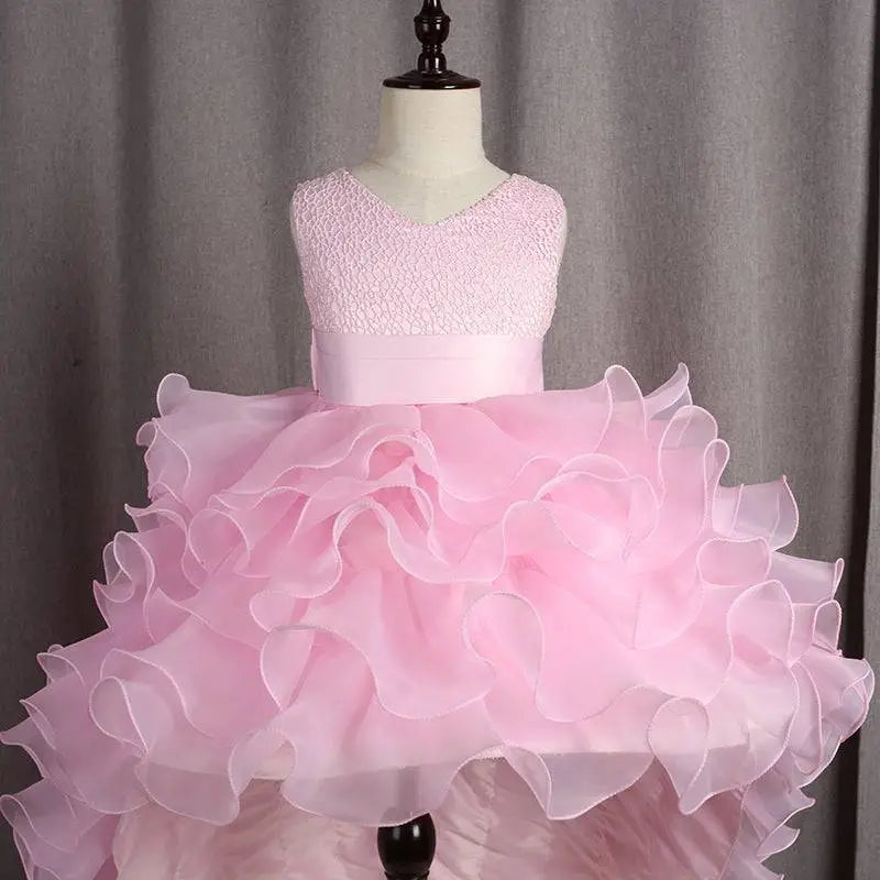 A delicate pink fuchsia layered ruffled flower girl tuxedo dress with lace bodice and trailing tulle skirt