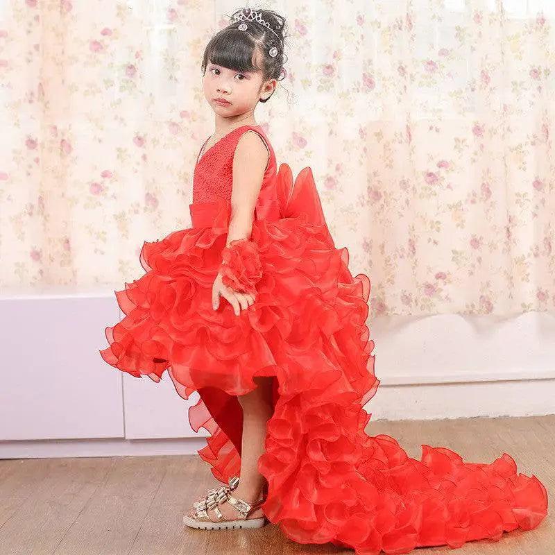 A vibrant fuchsia layered ruffled flower girl tuxedo dress with lace bodice and trailing design