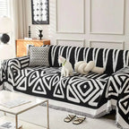 Geometric black and white chenille sofa cover with fringed edges on a white chenille sofa for stylish protection