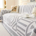 Geometric black and white chenille sofa cover with gray and white pattern and fringed edges for stylish protection