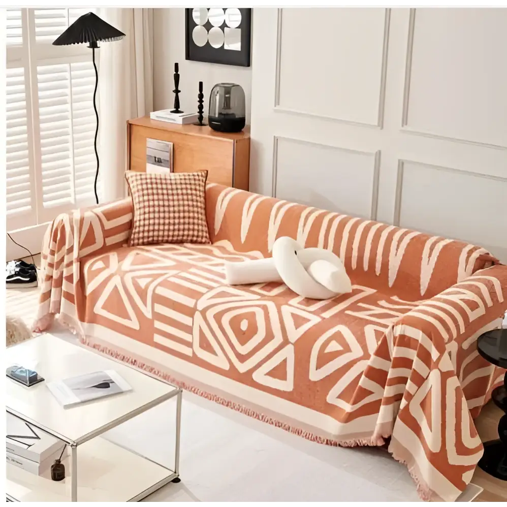 Orange and white geometric chenille sofa cover with fringed edges complementing geometric black and white chenille sofa cover