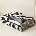 Geometric black and white chenille sofa cover featuring zebra-striped throw blanket with frayed edges for white chenille sofa