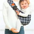 Geometric patterned black and white baby sling carrier with black and gray checkered fabric and colorful cartoon strap prints