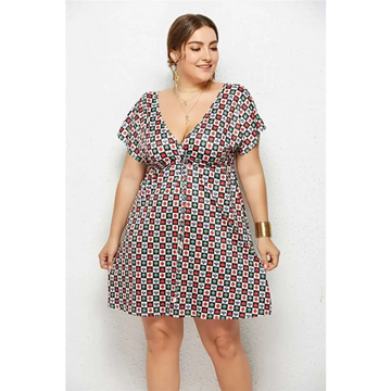 A plus-size woman wears a geometric printed deep v-neck dress with short sleeves and elastic waist in red green and white