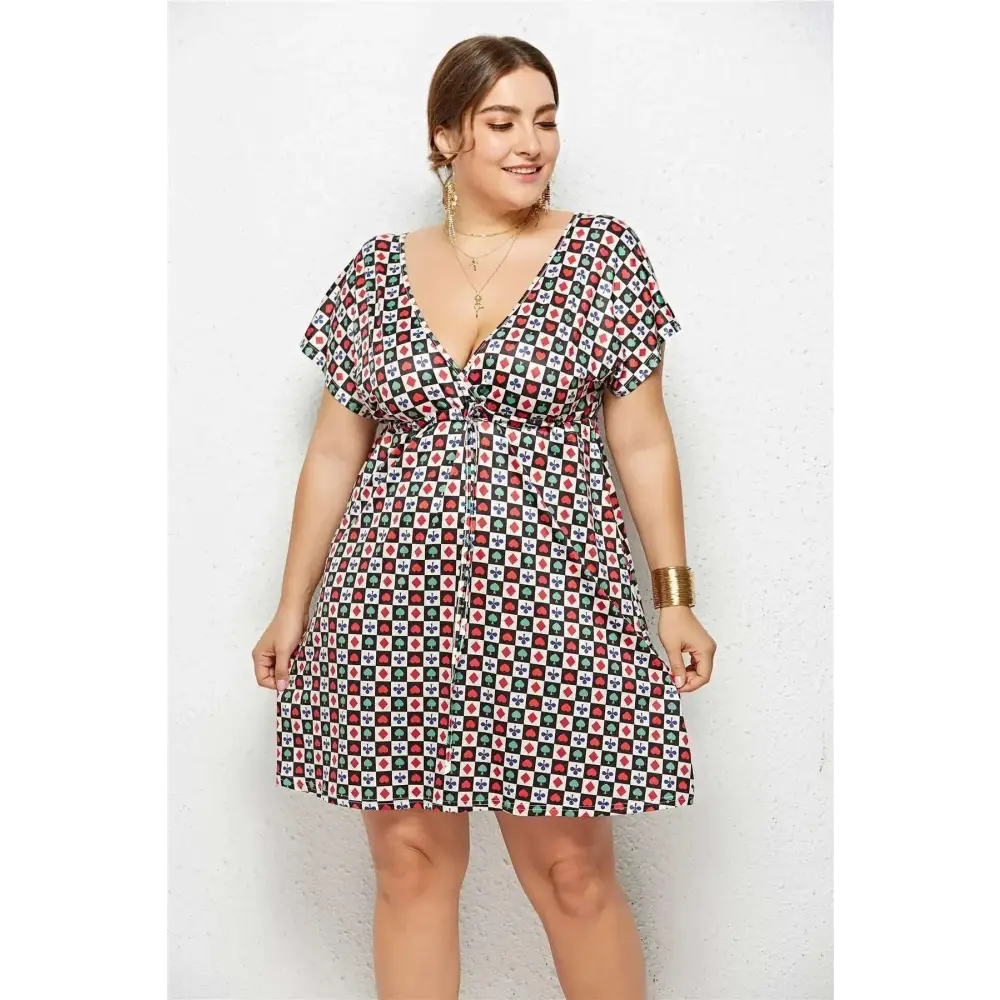 A plus-size woman wears a geometric printed deep v-neck elastic waist dress with red green and white short sleeves