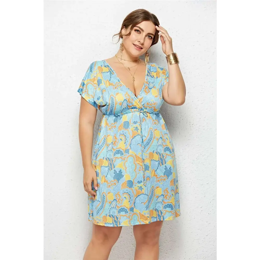 A light blue and yellow geometric printed deep v-neck elastic waist short-sleeved dress with wrap-style bodice and belt